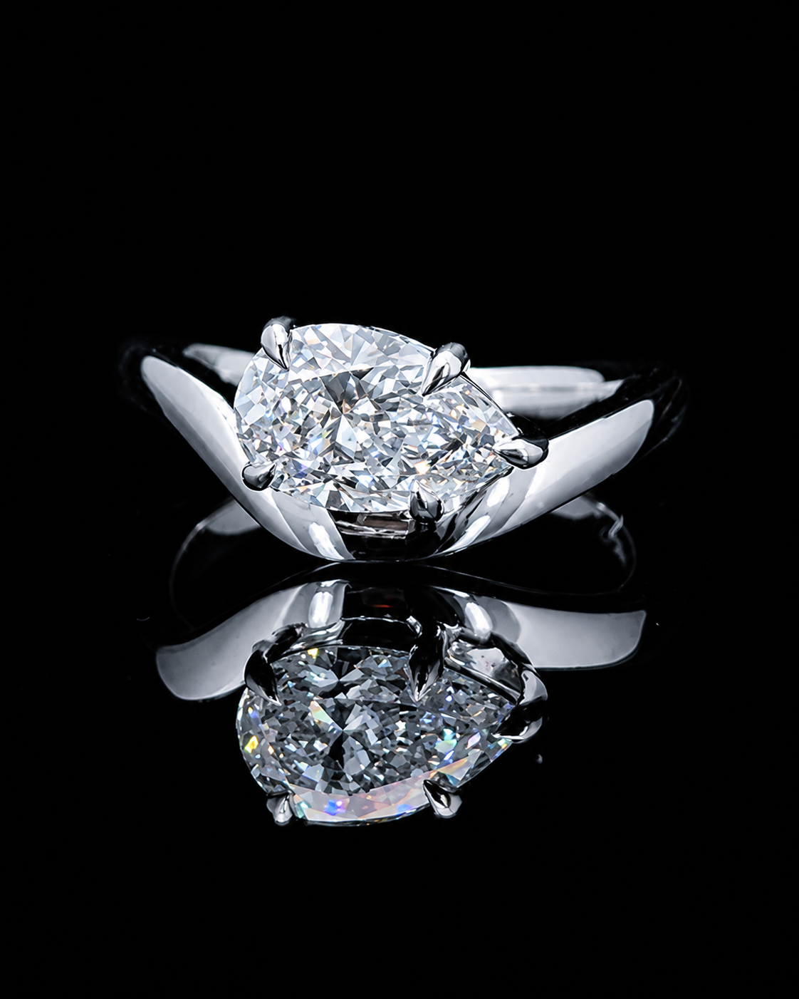 Main: White gold 1.00ct pear twist solitaire ring with lab grown diamond centre on black
Detail: Close-up of 1.00ct pear lab grown diamond held in a sculptural white gold setting
Side: White gold pear solitaire ring with flowing crossover twist shoulders and raised setting