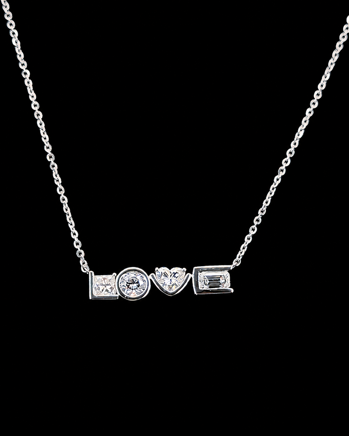 Main: White gold LOVE pendant with princess, round, heart and emerald lab grown diamonds on black
Detail: Close-up of mixed-cut lab grown diamonds forming a white gold LOVE pendant
Side: White gold LOVE pendant showing individual mixed-cut lab grown diamond settings