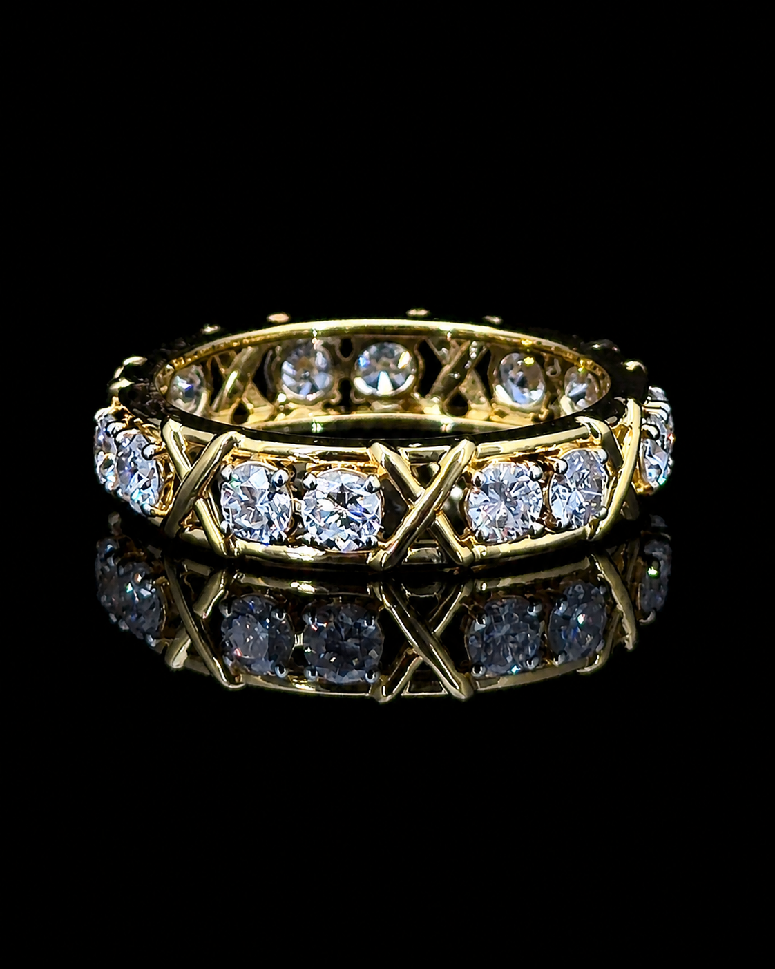 Yellow gold X-motif eternity ring with 1.40ct round lab grown diamonds on black
