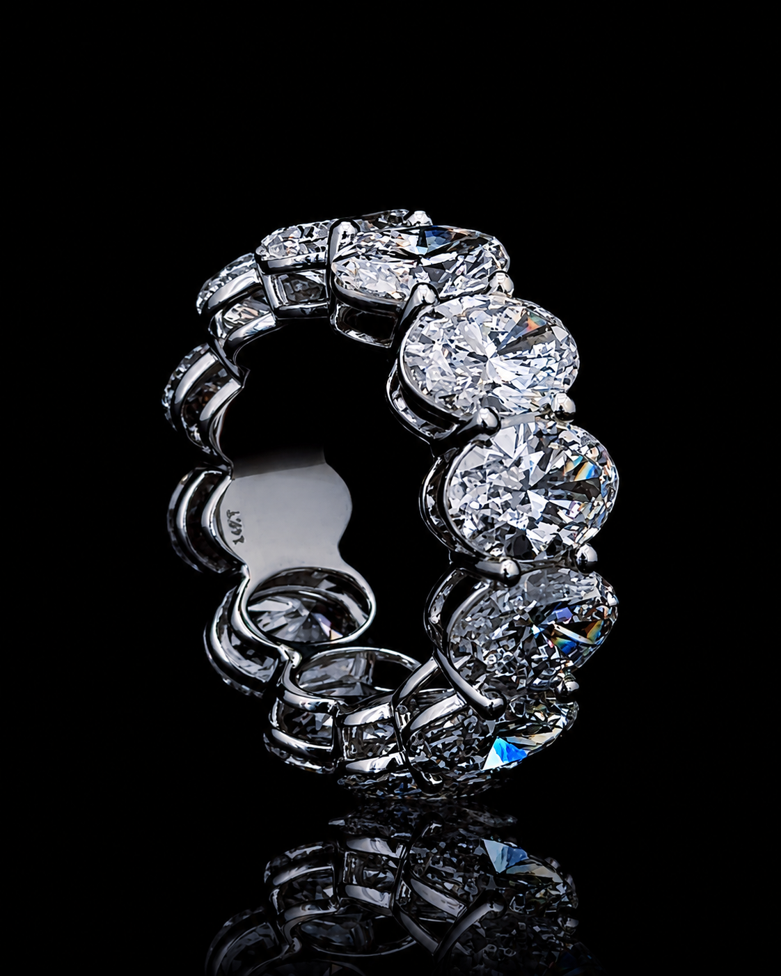 White gold oval eternity ring with 13 oval and round accent lab grown diamonds on black
