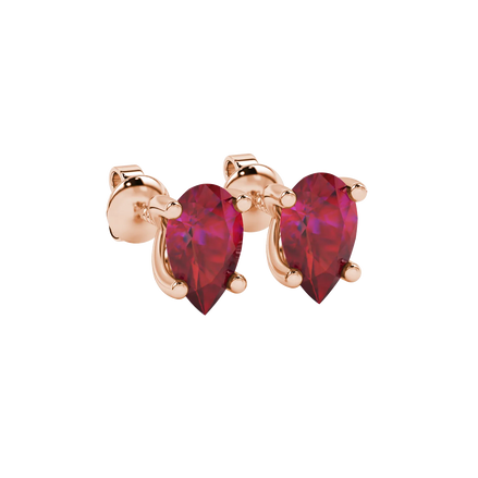 Close-up, pear shape raspberry red gemstone earrings, rose gold four-prong setting.
