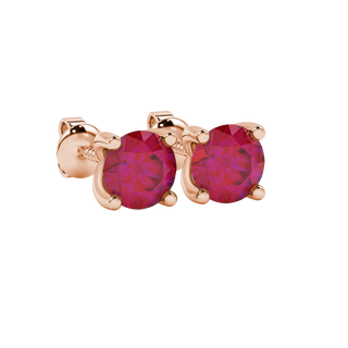 Close-up shot of round raspberry red gemstone earrings with a rose gold surprise diamond setting design.