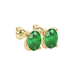 Close-up, oval cut emerald green gemstone, yellow gold four prong earrings.