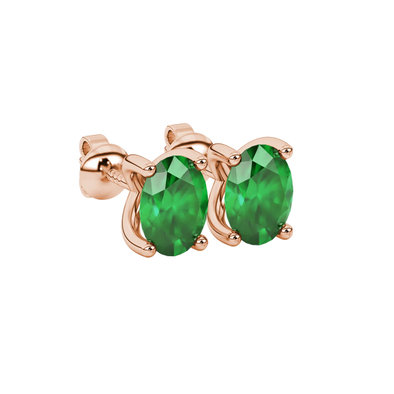 Close-up, oval cut emerald green gemstone earrings, rose gold four prong setting.