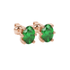 Close-up, oval cut emerald green gemstone earrings, rose gold six prong setting.