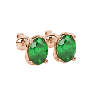 Close-up, oval cut emerald green gemstone earrings, rose gold classic basket.
