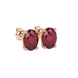 Close-up, oval cut raspberry red gemstone earrings, rose gold pavé basket.