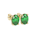 Close-up, oval cut emerald green gemstone, yellow gold pavé basket earrings.