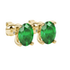 Close-up, oval cut emerald green gemstone, yellow gold surprise diamond earrings.