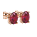 Close-up, oval cut raspberry red gemstone earrings, rose gold surprise diamond setting.