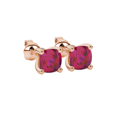 Red cushion cut solitaire stud earrings with accent diamonds in white gold four prong setting