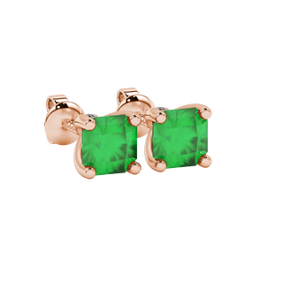 close-up shot of radiant-cut emerald green gemstone stud earrings with a rose gold surprise diamond accent.