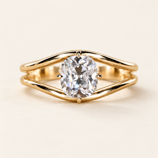 Cushion old mine cut lab grown diamond split shank engagement ring in yellow gold with two curved arms and four tapered prongs