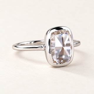 Elongated cushion rose cut lab grown diamond bezel engagement ring in white gold with a broad rounded rim and plain polished band