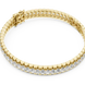 Gold bracelet with clear stones on a white background