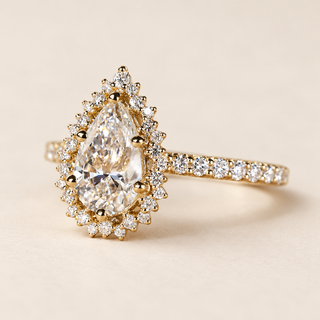Pear cut lab grown diamond halo engagement ring with 1.00 ct center, scalloped round diamond halo and pavé shoulders in polished yellow gold.
