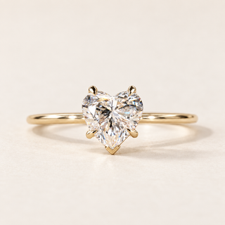Heart cut lab grown diamond solitaire engagement ring in yellow gold with four claw prongs, a V-shaped point guard and a plain band