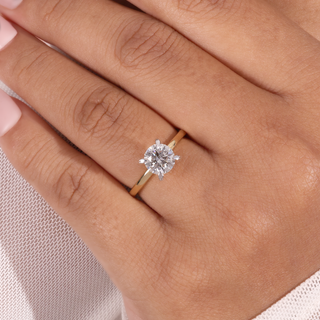 Yellow gold round lab grown diamond engagement ring with a four-prong center and plain polished shoulders.