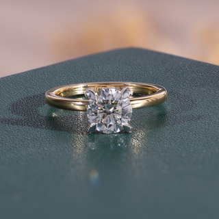 Yellow gold round lab grown diamond engagement ring with a four-prong center and plain polished shoulders.