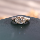 Yellow gold oval lab grown diamond men's signet ring with partial bezel setting and flush-set shoulder diamonds.