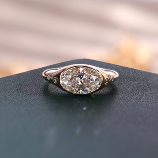Yellow gold oval lab grown diamond men's signet ring with partial bezel setting and flush-set shoulder diamonds.