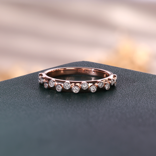 Rose gold round lab grown diamond anniversary ring with 16 circular bezel settings arranged at alternating heights.