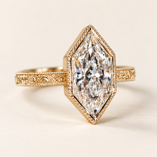 Dutch marquise cut lab grown diamond engagement ring with full geometric bezel, decorative milgrain edging and engraved vintage yellow gold shoulders.