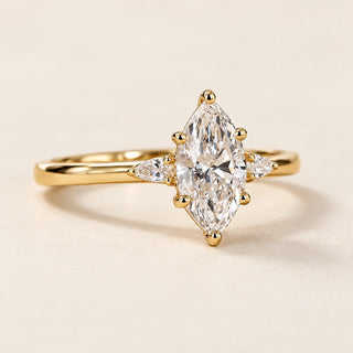Marquise cut lab grown diamond three-stone engagement ring with pear side diamonds in yellow gold
