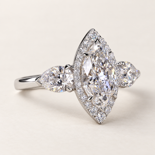 Marquise lab grown diamond three-stone engagement ring in white gold with pear side diamonds, pavé halo and protective V-prongs