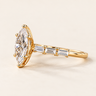 Marquise cut lab grown diamond engagement ring with 1.00 ct center, six-prong setting, protective tip prongs and six baguette diamond accents in yellow gold.