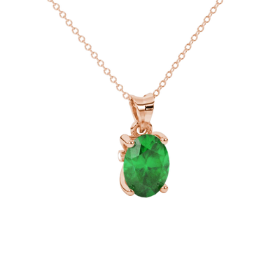 Close-up, oval cut emerald green gemstone pendant, rose gold surprise diamond setting.