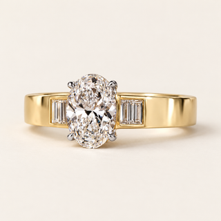 Oval cut lab grown diamond engagement ring with 1.00 ct center, four vertically aligned baguette diamond accents and broad polished yellow gold shoulders.