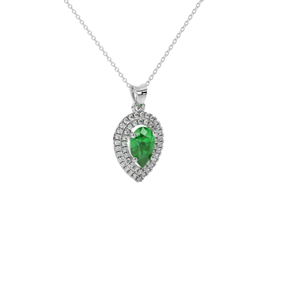 Close-up emerald green gemstone pendant, white gold halo setting.