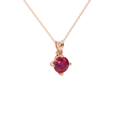 close-up shot of a round raspberry red gemstone pendant with a rose gold four-prong design.