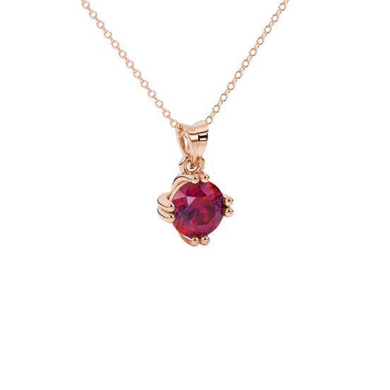 close-up shot of a round raspberry red gemstone pendant with a rose gold vintage basket design.
