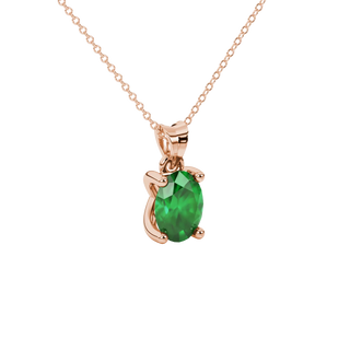 Close-up, oval cut emerald green gemstone pendant, rose gold four prong setting.