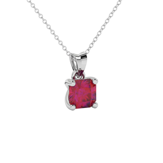 close-up of a radiant raspberry red gemstone enclosed in a white gold four-prong pendant setting.