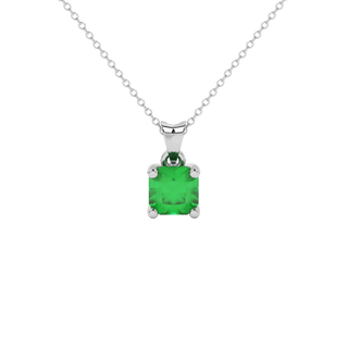 Radiant-cut emerald green gemstone pendant in a white gold surprise diamond setting.
