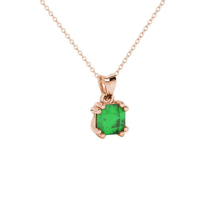 close-up shot of a radiant emerald green gemstone pendant with a rose gold vintage basket gallery.