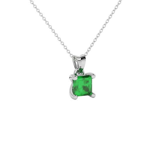 Close-up emerald green gemstone pendant, white gold four-prong setting.