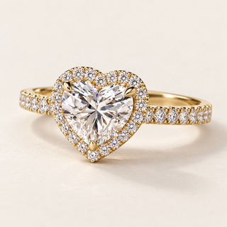 Heart cut lab grown diamond halo engagement ring in yellow gold with protective point prong and pavé diamond shoulders