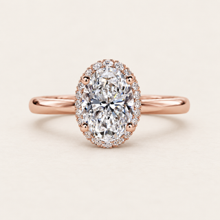 Oval cut lab grown diamond halo engagement ring with 1.50 ct center, round diamond halo and plain polished rose gold band.