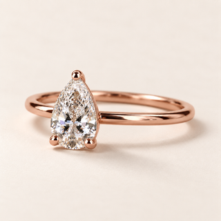Pear cut lab grown diamond solitaire engagement ring in rose gold with three rounded prongs and a plain polished band