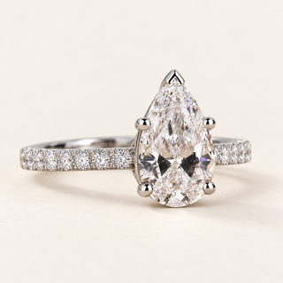 Pear cut lab grown diamond pavé engagement ring in white gold with V-prong pear center and continuous diamond shoulders