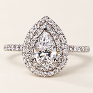 Pear cut lab grown diamond double halo engagement ring in white gold with three center prongs, pavé halos and diamond shoulders