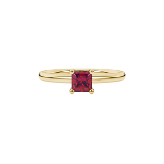 Close-up, princess raspberry red gemstone, yellow gold surprise ring.