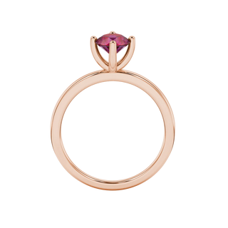 Round-cut raspberry red gemstone solitaire ring in a rose gold four-prong setting.