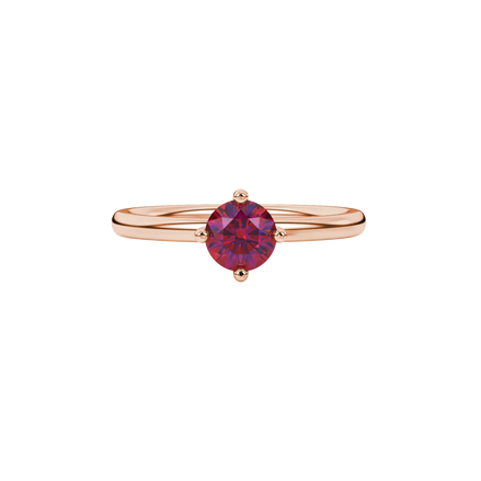 close-up shot of a round raspberry red gemstone ring with a rose gold four-prong design.