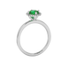 Side view of a white gold emerald green gemstone ring featuring a brilliant French pavé halo.