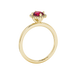 Side view of a yellow gold raspberry red gemstone ring with a detailed French pavé halo design.